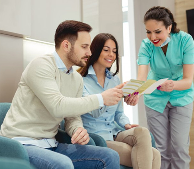 a couple of patients speaking with a front desk member