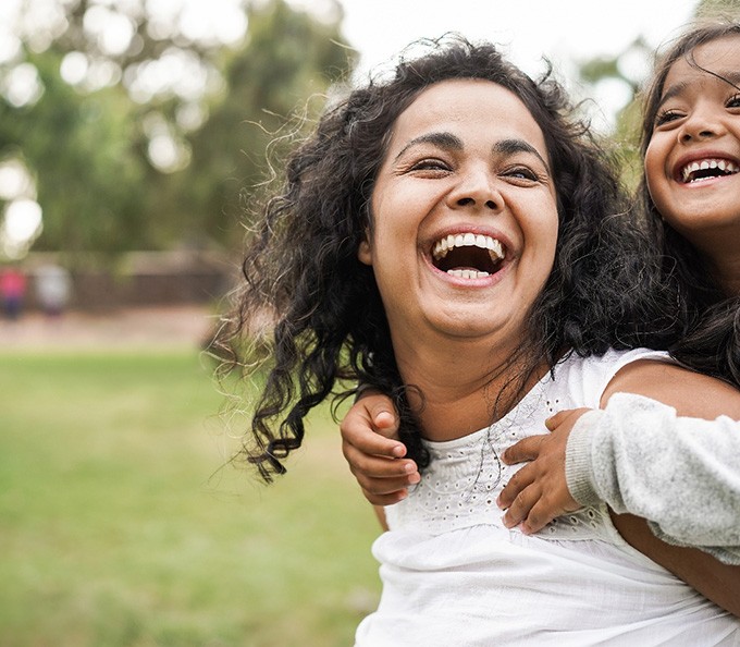 Happy mother and daughter playing outside