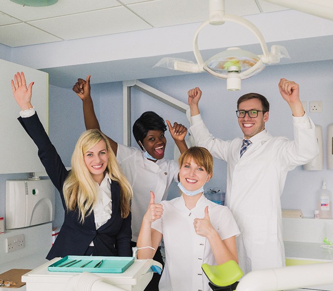 Dentist and team members in happy poses
