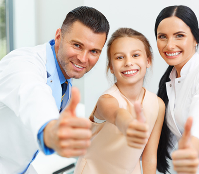 Young patient alongside dental team members 